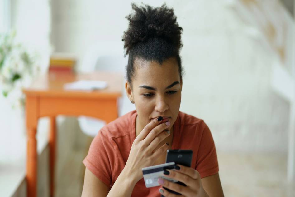 Person reviewing credit card statements at desk with debt payoff calculator